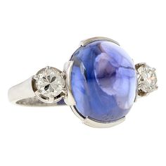 Centering a Sugarloaf cabochon sapphire weighing 13.50ct., flanked by two Round Brilliant cut diamonds weighing approx. 0.50ctw, fashioned in platinum. Stamped "PLATIN". Size 6 1/2. Sapphire Diamond Ring, Sapphire Diamond, Round Brilliant Cut Diamond, Brilliant Cut Diamond, Round Brilliant, Diamond Cuts, Diamond Ring, Platinum, Sapphire