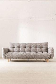 a gray couch sitting on top of a white floor