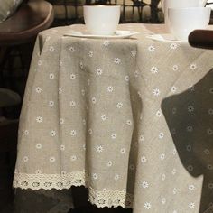 two cups are sitting on a table with white linens