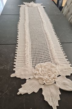 a table runner with crocheted flowers on it