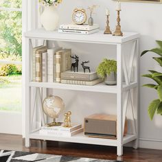 a white book shelf with books and other items on it in front of a window