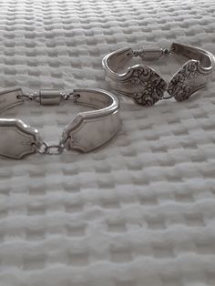 Handcrafted silver spoon bracelets. Measuring approximately 5 inches in diameter and will fit most wrists. Featuring two spoon handle gently curved to fit the wrist perfectly. Displaying 2 different styles. [SPB-A]is an intricate scroll design. [SPB-B] is a beautiful leaf and bow design. Each are secured with a magnet/screw combination clasp. Please refer to the photos for more information. Mad Maggie's Crafting With A Re-Purpose All items are upcycled and repurposed using treasures collected ov Mad Maggie, Silver Spoon Bracelet, Spoon Art, Spoon Bracelet, Silver Spoon, Silver Spoons, Scroll Design, Bow Design, Antique Shops