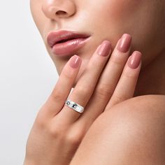 a woman's face with her hand on her shoulder, wearing a diamond ring