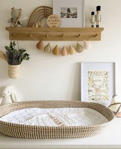 a baby's crib in the corner of a room with toys and pictures on the wall