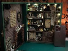 an open dollhouse with lots of stuff in it's display case and lights on the shelves