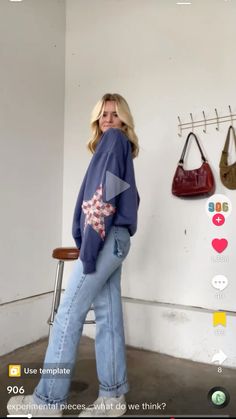 a woman standing in front of a wall with handbags hanging up on the wall