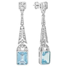 Top off your look with this spectacular pair of earrings. Coordinate them with your favorite outfit for a brilliant and lively appearance. The top of the solitaire drop earrings shows a beautiful cluster of round diamonds, in which the stunning spray design gently dangles below with the emerald cut blue topaz. Information Metal: 14K White Gold Width: 9 mm. Length: 50 mm. Weight: 9.18 g. (approx. in total) Backing: Push Back Center Gemstones Type: Blue Topaz Shape: Emerald Size: 10x8 mm. Number: Dubai Clothes, Emerald Cut Drop Earrings, Diamond Tiara, Earring Box, Women Diamond, Sapphire Earrings, Women Accessories Jewelry, Jewellery Designs, Silver Earrings Dangle