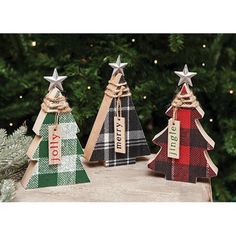 three wooden christmas trees with tags on them