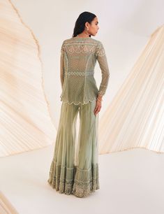 Editor's Note The Sharara set is accentuated by trellis-like detailing and pearl elegance, with neat tailoring and a scallop hem that make it a stylish choice for any special occasion. Color: Sage green Fabric: Organza, silk Fit type: Bustier: fitted, kurti: fit and flare Neckline: Kurti: v-neck Components: Sharara, bustier, kurti Occasion: Cocktail and Wedding Guest Care: Dry Clean Only About the Designer The crux and essence of the label, Divya Aggarwal, is to challenge and revamp the face of Fitted Kurti, Sheer Kurta, Sage Green Fabric, Embroidered Sharara, Blouse Yoke, Kurta Sharara, Padded Blouse, Embroidered Border, Scallop Hem