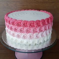 a pink and white cake on a glass plate