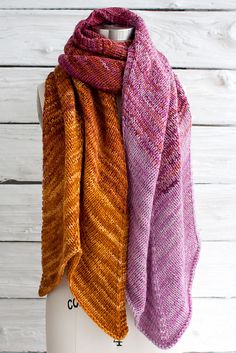 two scarves hanging on a wooden wall