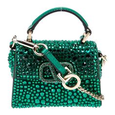 Valentino Garavani Emerald Green Vsling Micro Bag @Valentino Valentino Crossbody Bag Green Leather Gold-Tone Hardware Flat Handle & Single Adjustable Shoulder Strap Leather & Crystal Accents Leather Lining Snap Closure At Front Protective Feet At Base Estimated Item Measurements Shoulder Strap Drop: 21" Handle Drop: 0.75" Height: 3.75" Width: 4.5" Depth: 1" Designer Embellished Bags For Shopping, Luxury Green Handheld Evening Bag, Designer Green Evening Bags, Luxury Green Evening Bag With Detachable Handle, Green Luxury Evening Bag With Top Handle, Luxury Green Top Handle Evening Bag, Luxury Green Evening Bag With Top Handle, Luxury Green Shoulder Bag For Evening, Luxury Embellished Shoulder Bag For Shopping