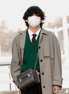 a man wearing a face mask while holding a briefcase