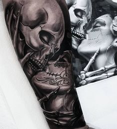 a man with a black and white tattoo on his arm next to a woman's skull