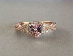 a pink diamond ring with two diamonds on it's sides and one stone in the middle