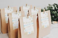 small brown paper bags with gold and blue snowflakes are lined up on a table