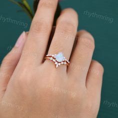 a woman's hand with a ring on it and flowers in front of her