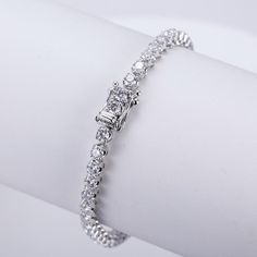 This timeless diamond tennis bracelet in 14K gold is a symbol of elegance and sophistication. Featuring a seamless row of brilliant-cut diamonds, this bracelet offers a radiant sparkle that complements any outfit. The meticulous craftsmanship is evident in each individually set diamond, designed to catch the light from every angle. A secure clasp with additional diamond accents ensures both style and safety. Whether for a special occasion or everyday luxury, this tennis bracelet is the perfect blend of classic beauty and modern grace, making it a cherished addition to any jewelry collection. Diamond White Jubilee Tennis Bracelet For Anniversary, Anniversary Cubic Zirconia Tennis Bracelet With Prong Setting, Dazzling Diamond Bracelet With Prong Setting For Anniversary, Anniversary Brilliant Cut Cubic Zirconia Tennis Bracelet, Cubic Zirconia Tennis Bracelet With Brilliant Cut For Anniversary, Anniversary Tennis Bracelet With Brilliant Cut Cubic Zirconia, Cubic Zirconia Tennis Bracelet For Anniversary, Diamond Tennis Bracelet With Prong Setting For Anniversary, White Gold Cubic Zirconia Tennis Bracelet For Anniversary