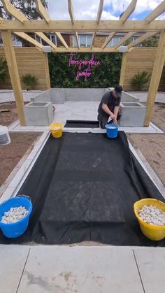 two buckets filled with white rocks sitting on top of a black tarp