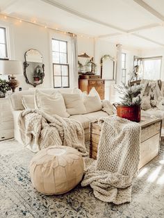 a living room filled with lots of furniture and pillows on top of a carpeted floor