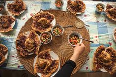 a table topped with lots of pies covered in toppings next to bowls of food