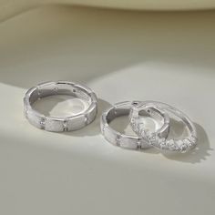 two white gold diamond hoop earrings sitting on top of a table next to each other