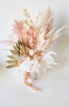 a vase filled with flowers and feathers on top of a table