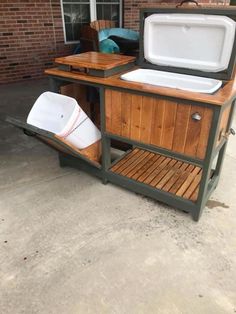 an outdoor kitchen made out of wood and metal with a cooler attached to the side