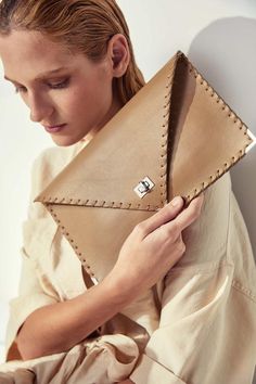 Symmetria mat clutch in sand beige.The perfect bag for all day needs, evening entertainment and going to a party.This adorable bag is handmade out of a supreme, cow, Italian leather in rsand beige color.It is hand stitched with waxed thread.The interior is fully lined with beige leatherette.The clutch closes with a metal twisted clasp and has metal endings, available in silver and gold color. The pictures show the clutch with gold metal hardware.Dimensions:Height 18 cm (7")Length 30 cm (11,8")Al Modern Beige Clutch For Evening, Luxury Brown Envelope Clutch, Luxury Beige Envelope Clutch, Beige Envelope Clutch For Evening, Modern Beige Clutch For Everyday Use, Beige Leather Clutch For Office, Elegant Beige Bag With Laptop Sleeve, Chic Beige Clutch For Office, Beige Leather Envelope Bag