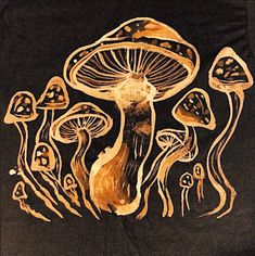 a group of mushrooms on a black t - shirt with gold foiling in the middle