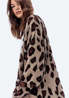 a woman is wearing a leopard print coat