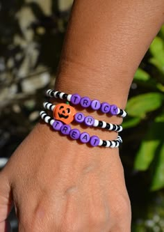 two bracelets that say trick or treat on the wrist and one with a jack - o'- lantern