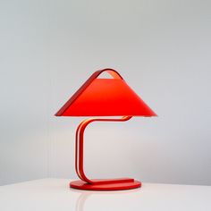 a red lamp sitting on top of a white table