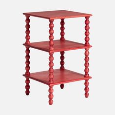 three tiered wooden shelf with red paint on the top and bottom, in front of a white background