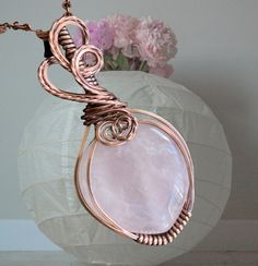 This listing is for the beautiful wire wrapped Pink Rose Quartz Pendant Necklace. This beautiful Pink rose quartz is wire wrapped in an antiqued copper wires. The pendant has been, hammered & forged to give strength & texture to bring out the stunning details of the finished pendant. The pendant comes with your choice of chain. The pendant measures 2 .00inch from the top of the bail to the bottom of the pendant, 1.5 inch across. *About Rose Quartz: Rose quartz is a stone of unconditional love. It opens the heart chakra to all forms of love: self-love, family love, platonic love, and romantic love. Rose quartz has excellent protection energies during pregnancy and childbirth. The elevated energy of quartz gives rose quartz a property of enhancing love in virtually any situation. Rose quartz Pink Rose Quartz Wire Wrapped Jewelry, Rose Gold Rose Quartz Hand-wrapped Jewelry, Hand Wrapped Rose Quartz Jewelry In Rose Gold, Pink Wire Wrapped Copper Jewelry, Pink Copper Wire Wrapped Jewelry, Pink Wire Wrapped Copper Wire Jewelry, Pink Copper Wire Jewelry For Gifts, Handmade Pink Copper Wire Jewelry, Rose Gold Wire Wrapped Copper Necklace