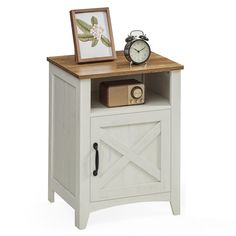 an alarm clock sitting on top of a wooden table next to a small cabinet with doors