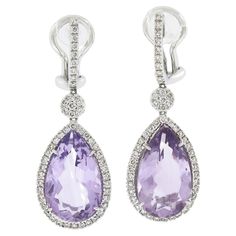 --Stone(s):-- 2 Natural Genuine Amethyst - Pear Cut - Prong Set - Lavender Purple Color - 16x9.5mm - 12ctw (approx.) 100 Natural Genuine Diamonds - Round Brilliant Cut - Pave Set - G-I Color - VS1/VS2 Clarity - 0.50ctw (approx.) Total Carat Weight: 12.50 (approx.) Material: Solid 18k White Gold Weight: 9.59 Grams Backing: Posts w/ Omega Closures (Pierced ears are required.) Width: 12.9mm (0.50") (approx.) Overall Height: 35.2mm (1.3") (approx.) Thickness: 7.4mm (at the amethyst), 3.3mm (projection off the ear at the hoop) Condition: Like New! Stock Number: MK-82077121-23091517-PAR-EY Lavender Purple Color, Pearl And Diamond Ring, Drop Dangle Earrings, Lavender Purple, Fine Jewellery Earrings, Gold Pearl, Gorgeous Earrings, Pear Cut, Purple Amethyst