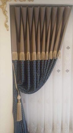 a curtain with tassels hanging from it's side in front of a window