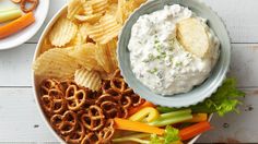 a plate filled with crackers, pretzels and dip