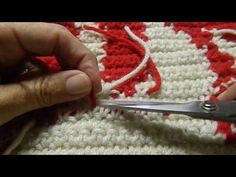 someone is using scissors to cut the crochet