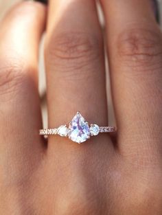 a woman's hand with a ring on it and a diamond in the middle