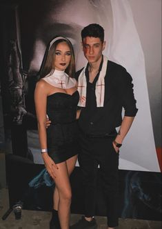 two people standing next to each other in front of a movie poster and posing for the camera