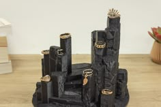 a black and gold castle made out of rocks with rings on it's sides