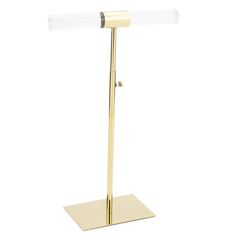 a gold metal and glass desk lamp with a white light on the top of it