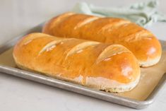 two loaves of bread sitting on top of a metal tray next to each other