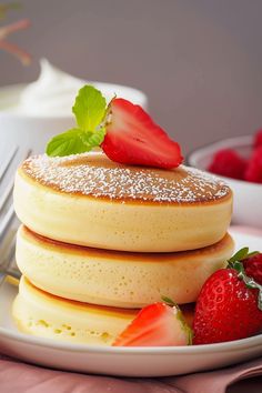 pancakes with powdered sugar and strawberries on a plate