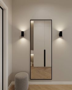 an empty room with some lights on the wall and a large mirror in the corner