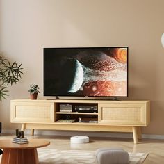 a flat screen tv sitting on top of a wooden entertainment center in a living room