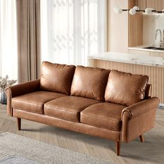 a brown leather couch sitting in a living room next to a white rug and window