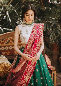 White and Green Lehenga Choli for Wedding Wear is stunningly embroidered in dabka, tilla, and sequins work on white raw silk choli paired with Raw Silk Green Lehenga and Net Pink Dupatta. ﻿A blossoming pink hue dupatta is paired up with a handcrafted mastery of pearls, zardosi, and sequins laid over an emerald green lehenga and a white choli in pure raw silk. Choli: Beautiful dress is gonna make your big day more beautiful in its design and styling having embroidered choli in without sleeves inc Lehenga Choli For Wedding, Asian Attire, Choli For Wedding, Wedding Makeover, Green Lehenga Choli, Silk Fabric Dress, Haldi Outfits, Pink Dupatta, Indian Outfits Lehenga